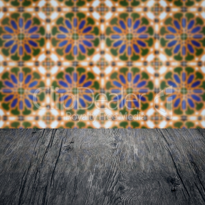 Wood table top and blur vintage ceramic tile pattern wall