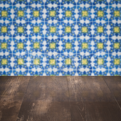 Wood table top and blur vintage ceramic tile pattern wall