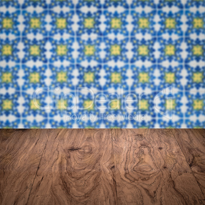 Wood table top and blur vintage ceramic tile pattern wall