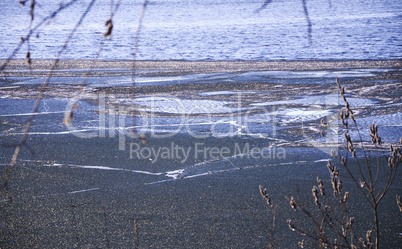 Spring landscape with melting ice on the lake on a clear day