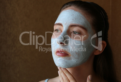 girl doing cosmetic mask on her face