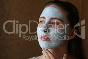 girl doing cosmetic mask on her face
