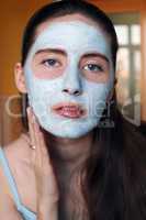 woman doing cosmetic mask on her face
