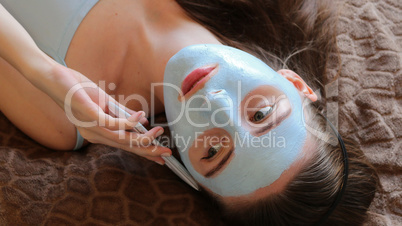 girl with cosmetic mask her face talking on the smartphone