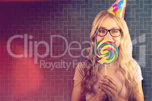 Composite image of a beautiful hipster holding a giant lollipop