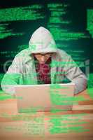 Composite image of man with hooded shirt working on laptop