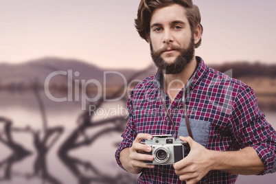 Composite image of portrait of confident hipster using camera