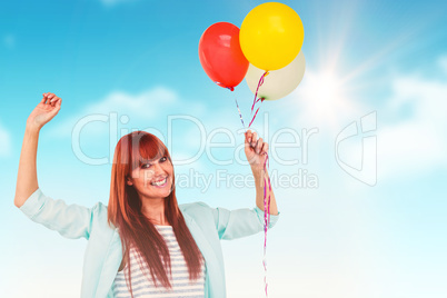 Composite image of smiling hipster woman holding balloons