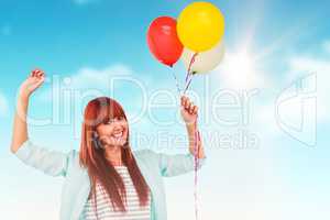 Composite image of smiling hipster woman holding balloons
