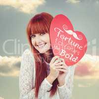Composite image of smiling hipster woman with a big red heart