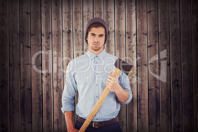 Composite image of portrait of serious hipster holding axe