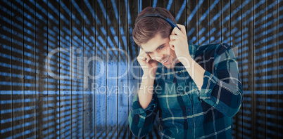 Composite image of hipster smiling while wearing headphones