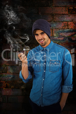 Composite image of portrait of hipster smiling while holding smo