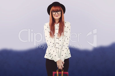 Composite image of smiling hipster woman holding book belt