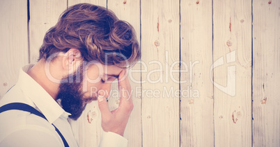 Composite image of frustrated hipster with head in hand