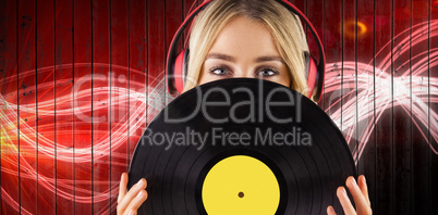 Composite image of portrait of a beautiful woman holding a vinyl