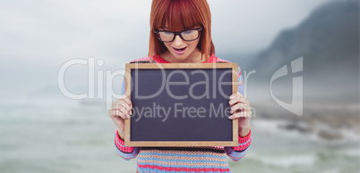 Composite image of smiling hipster woman holding blackboard