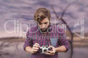 Composite image of hipster using camera