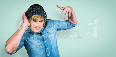 Composite image of cheerful hipster listening to music