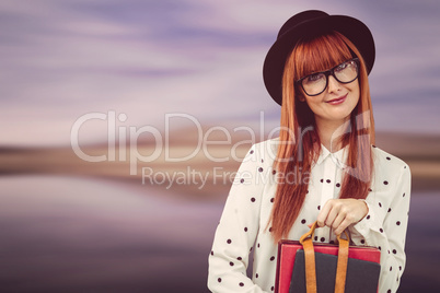 Smiling hipster woman holding book belt