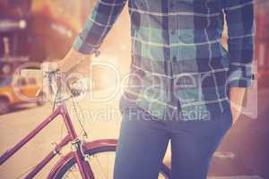 Composite image of mid section of hipster with bicycle
