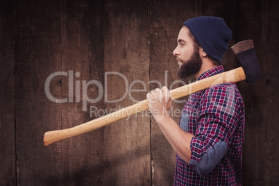 Composite image of side view of hipster with axe on shoulder