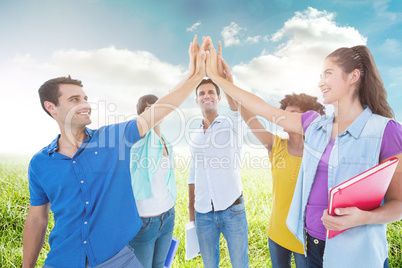 Composite image of young business people putting their hands tog