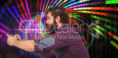 Composite image of side view of happy hipster playing video game