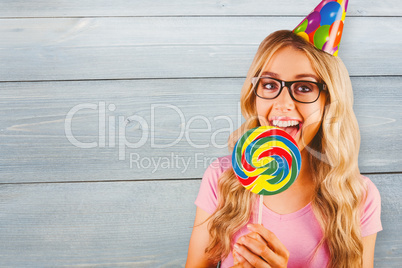 Composite image of a beautiful hipster holding a giant lollipop