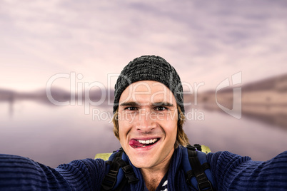Composite image of backpacker holding the camera and grimacing