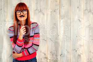 Composite image of smiling hipster woman with a mustache