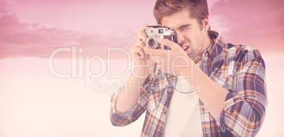 Composite image of hipster photographing against wooden wall