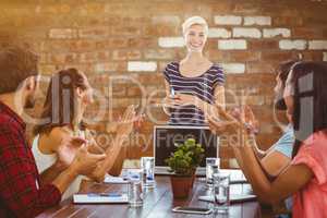 Composite image of colleagues clapping hands in a meeting