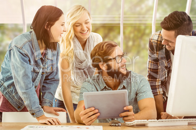 Composite image of happy business people using digital tablet at