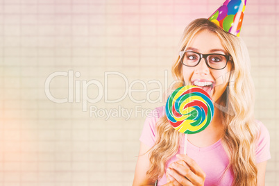 Composite image of a beautiful hipster holding a giant lollipop