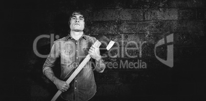 Composite image of front view of hipster standing with axe