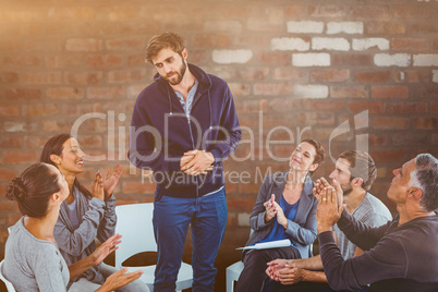 Composite image of rehab group applauding delighted man standing