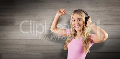 Composite image of portrait of a beautiful woman dancing with headphones
