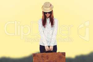 Composite image of portrait of a hipster woman holding suitcase