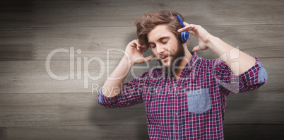 Composite image of hipster wearing headphones