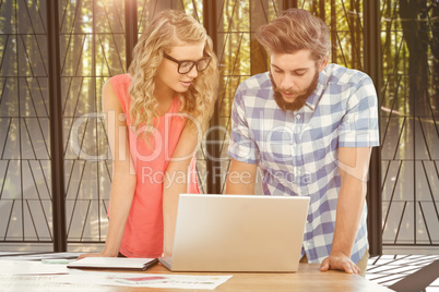 Composite image of man using laptop while discussing with woman