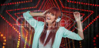 Composite image of happy hipster woman listening music with headphone