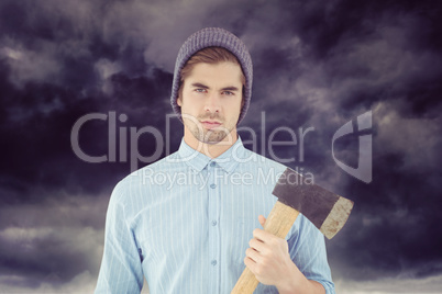 Composite image of portrait of serious hipster holding axe