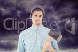 Composite image of portrait of serious hipster holding axe