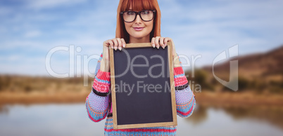 Composite image of smiling hipster woman holding blackboard