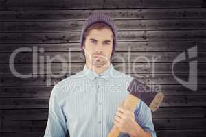 Composite image of portrait of serious hipster holding axe