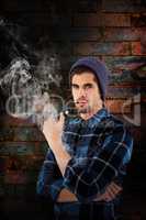 Composite image of portrait of hipster holding smoking pipe