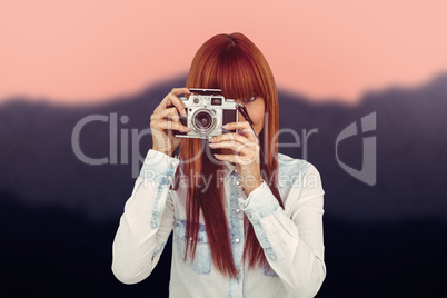 Composite image of attractive hipster photographing with camera