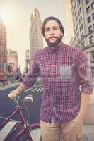 Composite image of portrait of confident hipster with bicycle