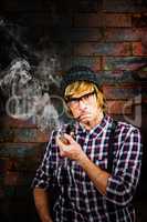 Composite image of serious blond hipster smoking a pipe